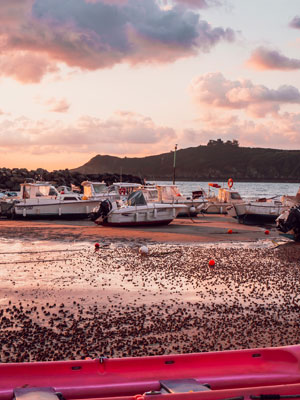 De haven bij eb en zonsondergang in Bretagne, Frankrijk